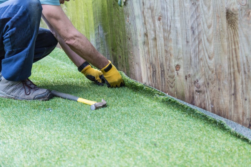 man installing artificial turf